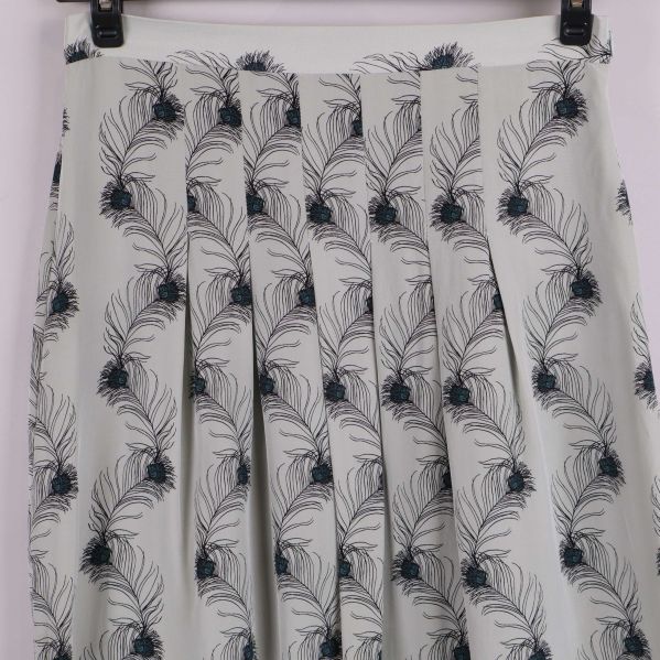 Detaljbild på plisserad kjol med fjädermönster