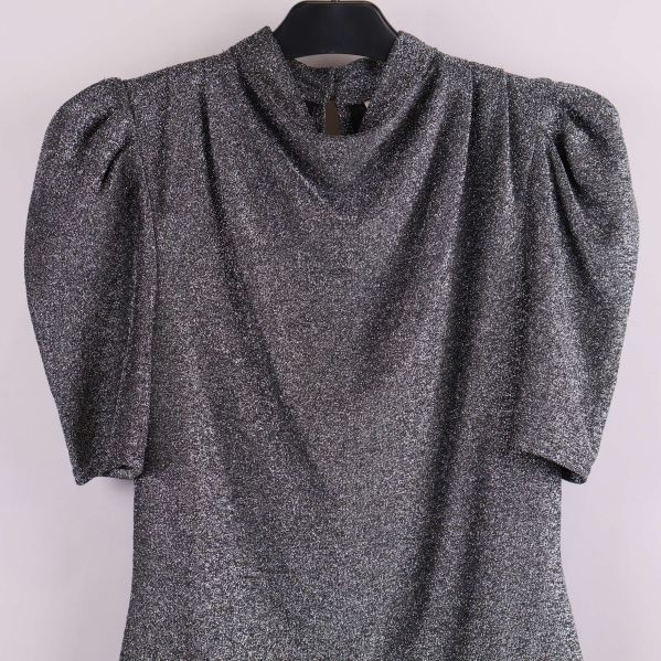 Närbild på överdel av glittrig topp med puffärm