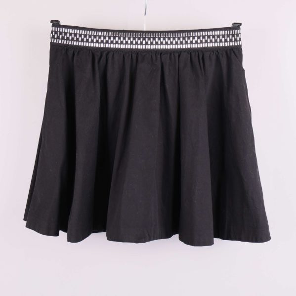 Kort svart kjol med dekorerad linning framifrån