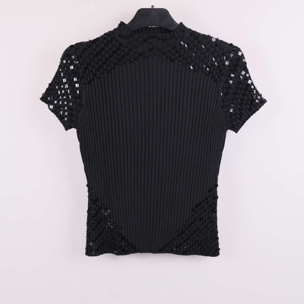Svart ribbad topp med paljettdetaljer sedd framifrån