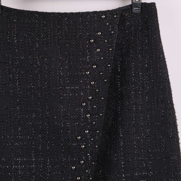 Närbild av kjolens framsida visar nitar och tygstruktur