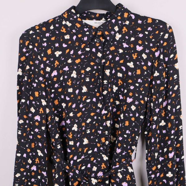 Detaljbild på överdelen och knäppning av klänningen