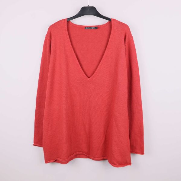 Röd stickad v-ringad tröja framifrån på galge