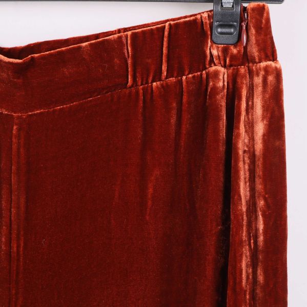 Närbild på sammetsbyxans midjedetalj i rostbrun färg