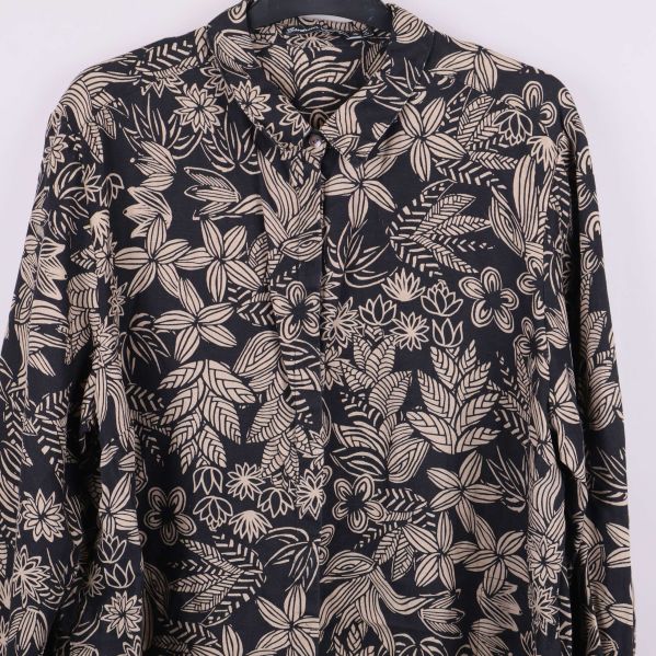 Närbild av blommigt mönster på tunikans framsida