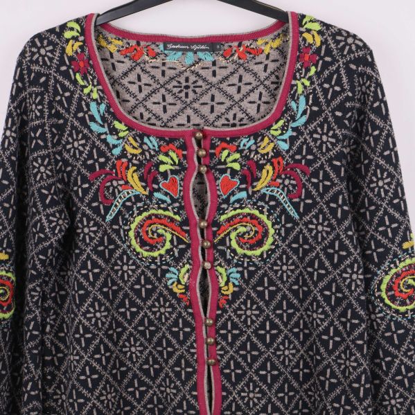 Närbild framtill på kofta med brodyr runt knappar