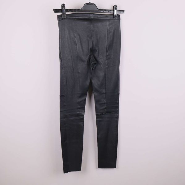 Baksida av svarta byxor i läderlook på galge