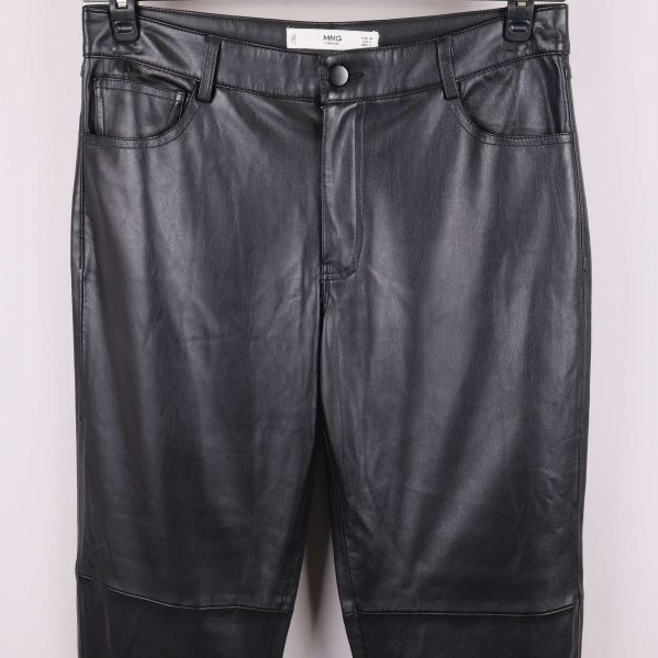 Närbild på framfickor och knapp på svarta konstläderbyxor