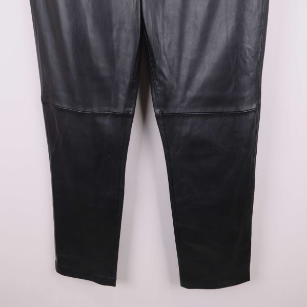 Nedre delen av benen på svarta konstläderbyxor