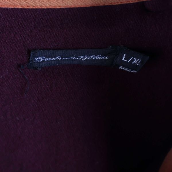 Närbild på svart etikett i nacken med storlek och text