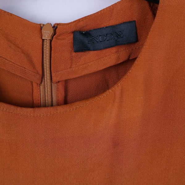 Närbild på halsringning och varumärkesetikett från And Other Stories