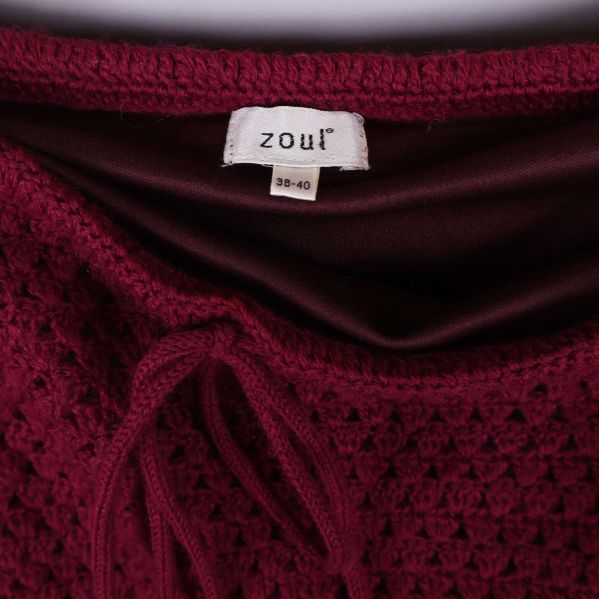 Nederkant av mörkröd stickad kjol i närbild