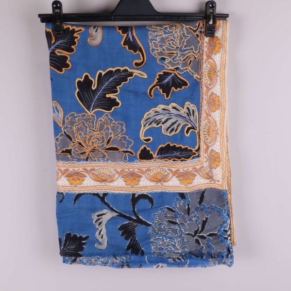 Blå sjal med blommigt mönster vikt på en galge