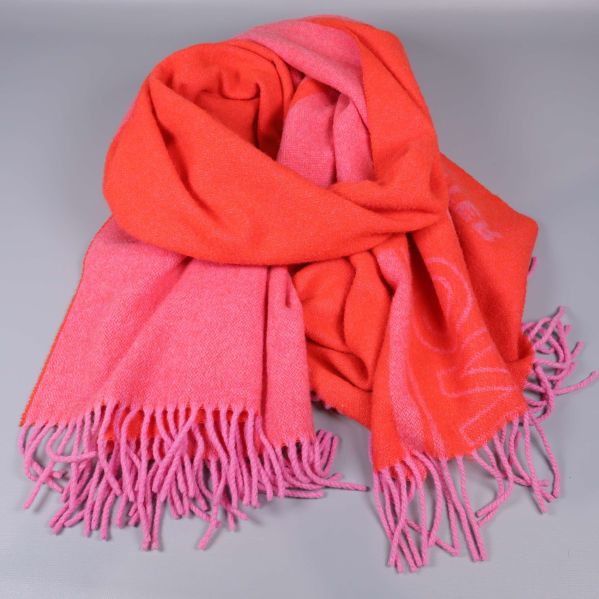 Rosa och orange halduk med fransar liggande ihopvikt