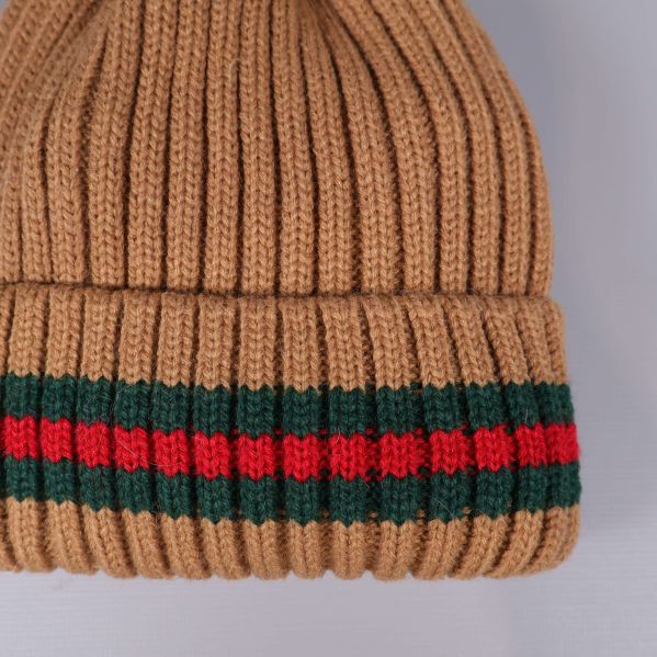 Närbild av randigt uppvik på beige mössa