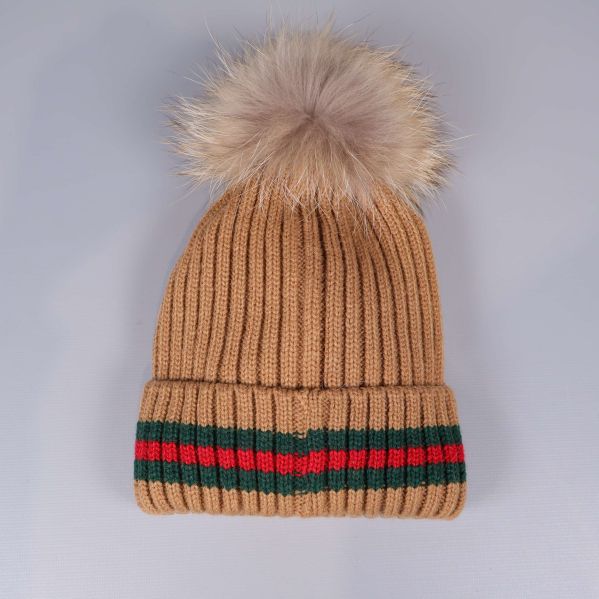 Framsidan av beige mössa med tofs och randigt uppvik