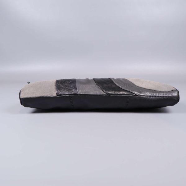 Botten på clutch med skinnpaneler i svart och grått