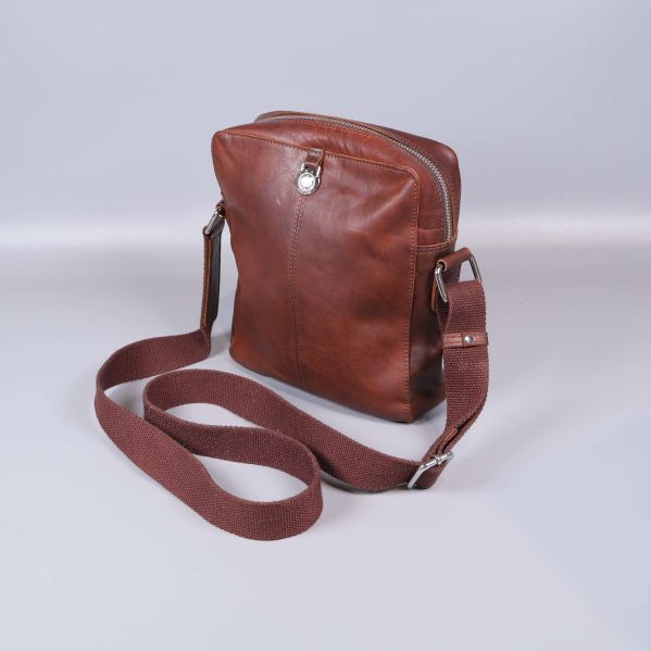 Axelremsväska i brunt läder med justerbar rem sedd snett framifrån