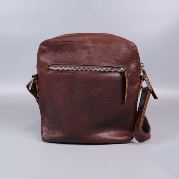 Bakre vy av brun axelremsväska i läder mot grå bakgrund