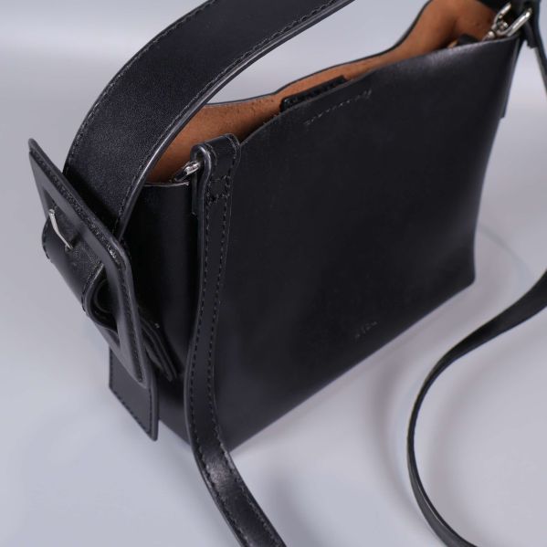 Närbild på väska, visar strukturen och axelrem med spänne