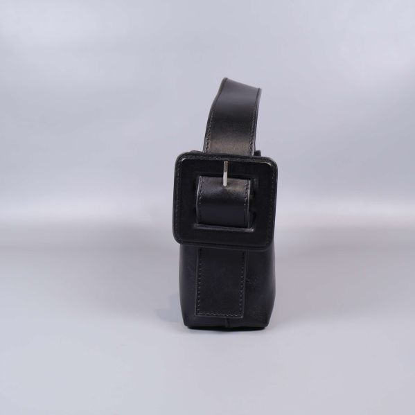 Sidovy på väska med fyrkantigt spänne i fokus