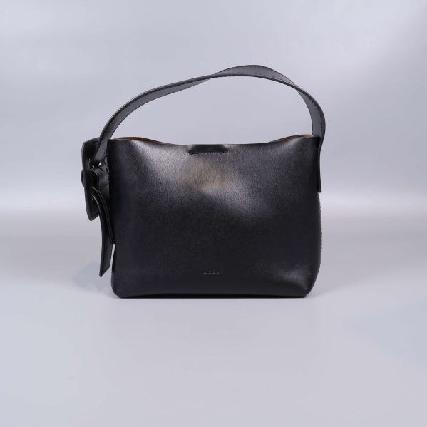 Framsida av svart väska med bred rem och glänsande yta