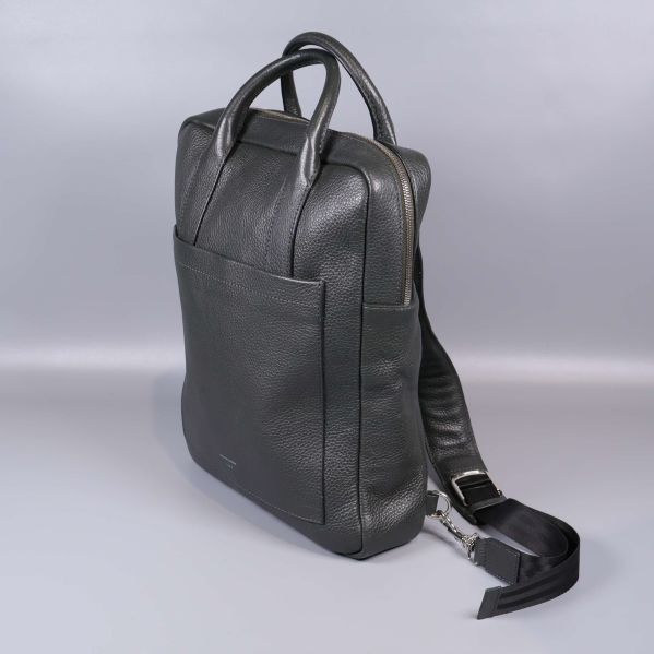 Svart läderryggsäck snett bakifrån med handtag och axelremmar