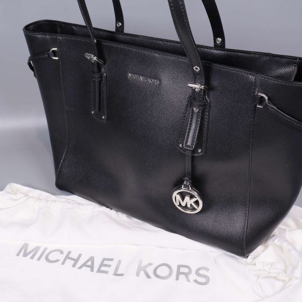 Närbild på svart Michael Kors väska och logotyp