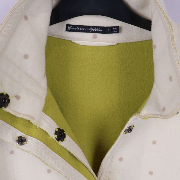 Närbild av krage och foder i limegrönt på kappan