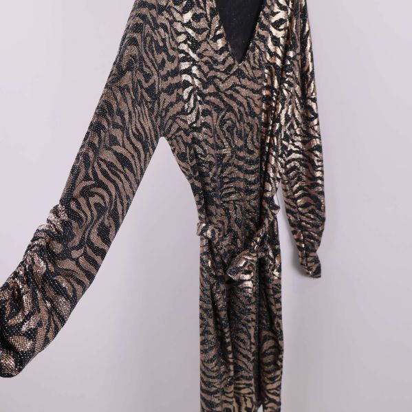 Detaljbild på lång ärm och glittrande tyg med djurmönster