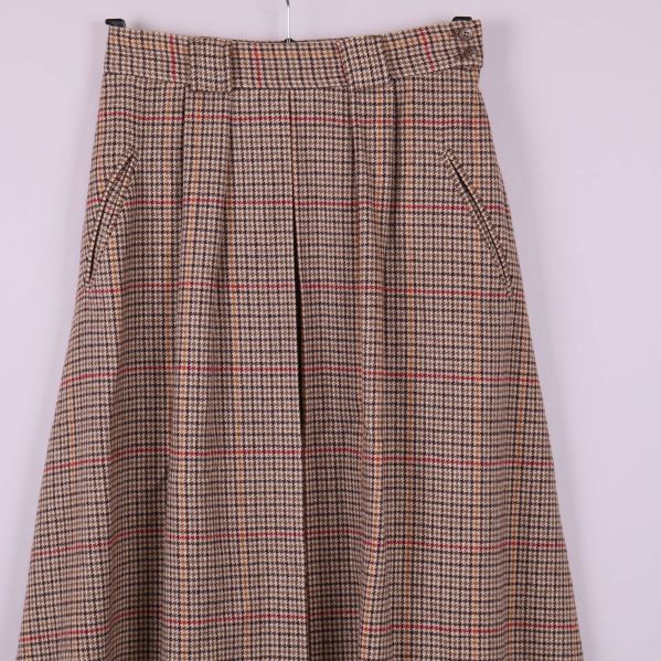 Framstycke på rutigt kjoltyg med pressveck och fickor