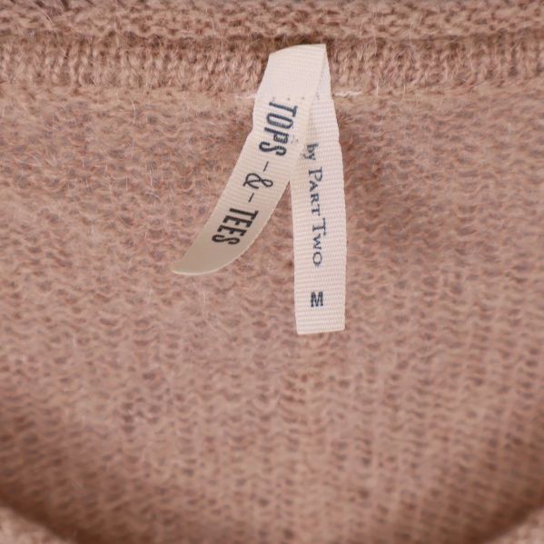 Närbild på etikett med texten Tops & Tees by Part Two