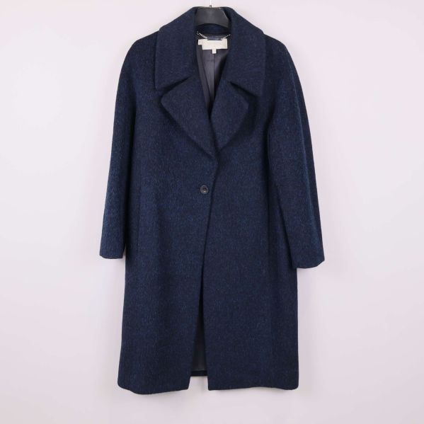 Mörkblå kappa med bred krage upphängd mot ljus bakgrund