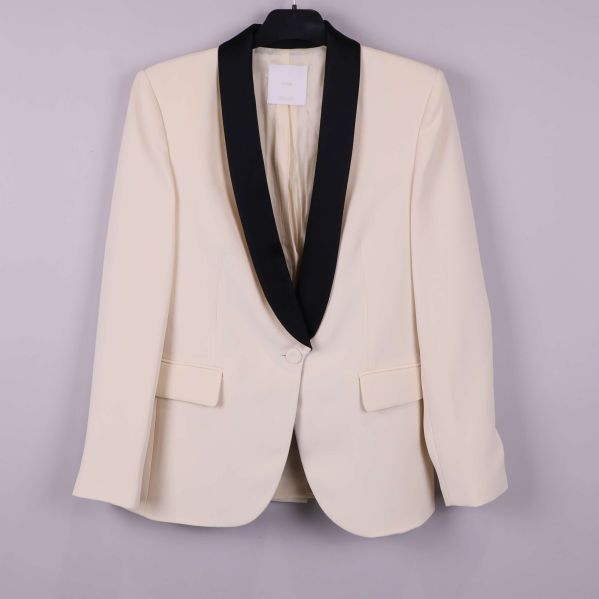 Framsida av cremevit kavaj med svart krage