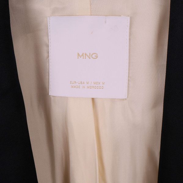 Närbild på MNG-etikett i kavajens nacke