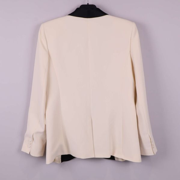 Baksidan av cremevit kavaj med slits