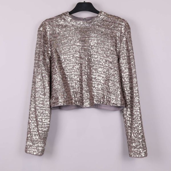 Paljettopp med långa ärmar sedd framifrån på galge