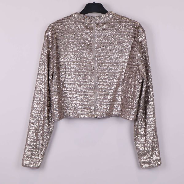 Paljettopp med dragkedja sedd bakifrån på galge