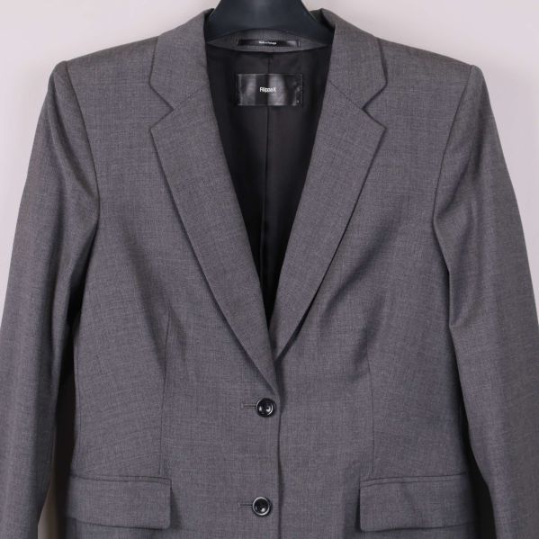 Närbild på övre delen av grå kavaj