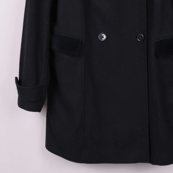 Närbild på kappans nedre framdel och fickornas detaljer