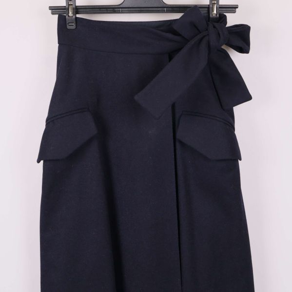 Närbild av fickor och knytdetalj framtill på kjolen