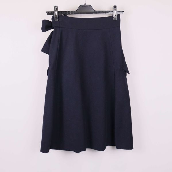 Baksidan av mörkblå kjol med fickor och knyte i midjan