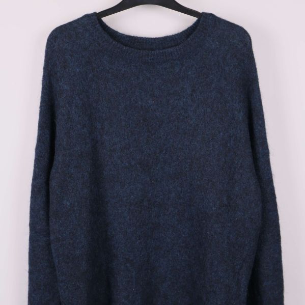 Närbild på överdelen av blå stickad tröja med rund hals