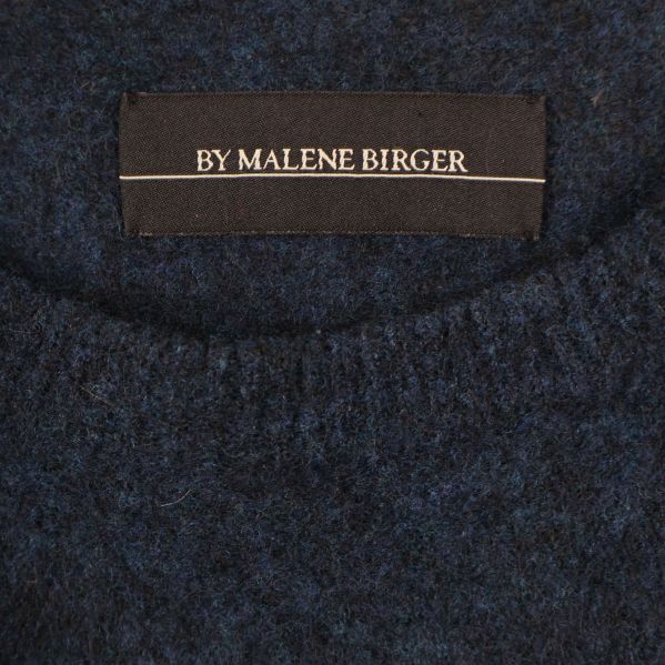 Närbild på By Malene Birger-logotyp vid halsringning