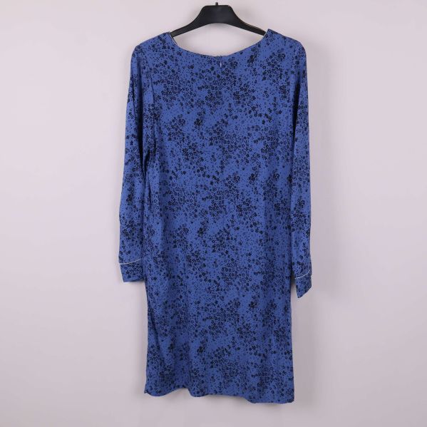 Klänning med blommönster visad bakifrån på galge