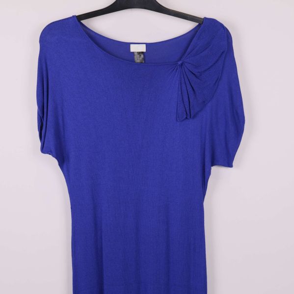 Närbild på axel med drapering på kornblå klänning