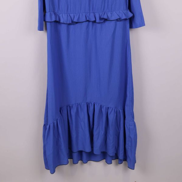 Närbild på nedre volangkant av blå klänning