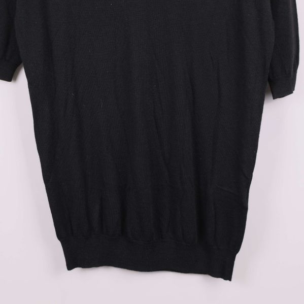 Detalj av nederkanten på svart tröja med resår