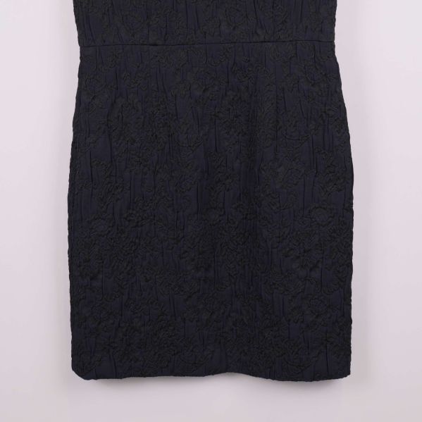 Närbild på kjoldel av klänningen och dess spetsmönster