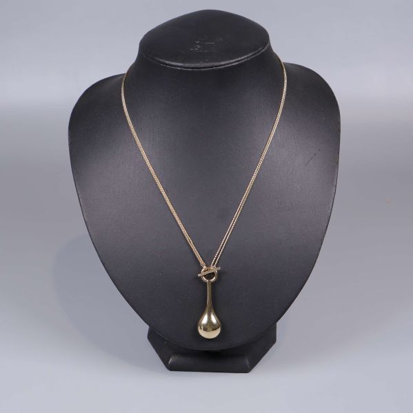 Halsband med droppformat hänge visas på bystställ